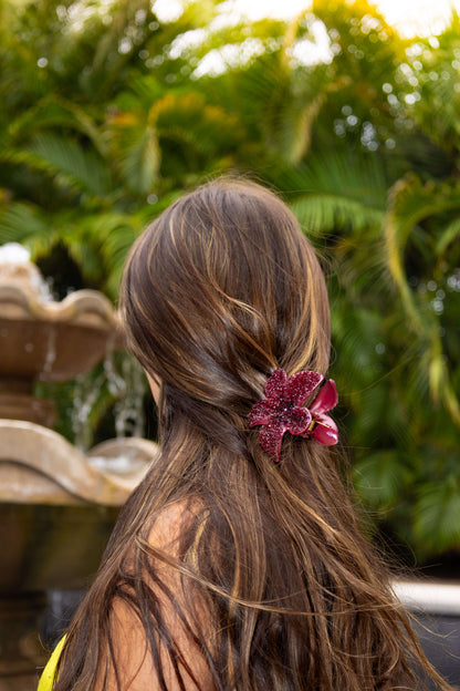 Model wearing a diamanté burgundy red floral clip in long hair